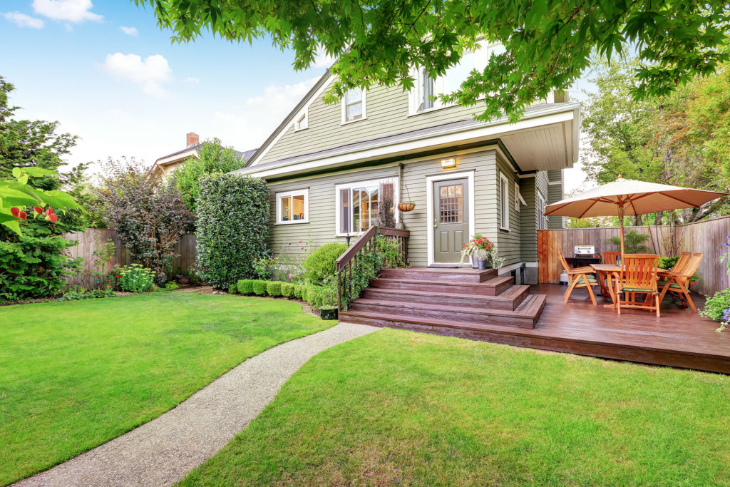 Backyard area with walkout deck, patio table set and well kept lawn. Northwest, USA