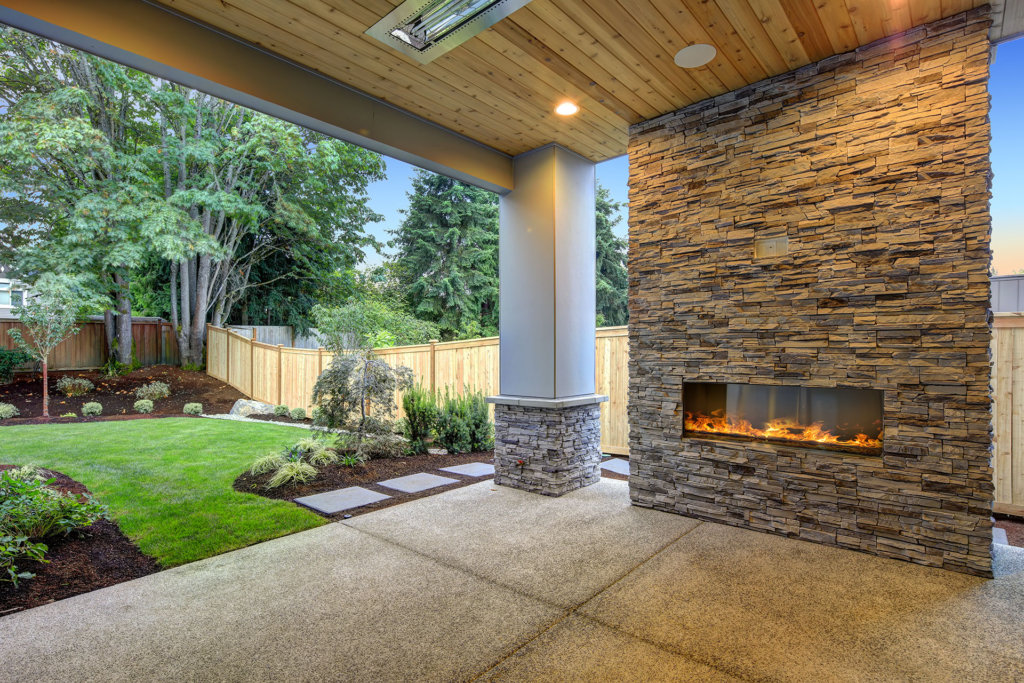 Outside Patio features natural wood plank ceiling, concrete floor and oversized stone fireplace overlooking a beautiful expansive yard. Northwest, USA
